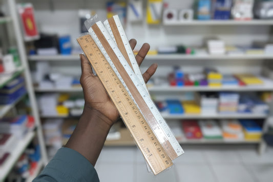 Hand holding a set of wooden rulers with a cluttered background