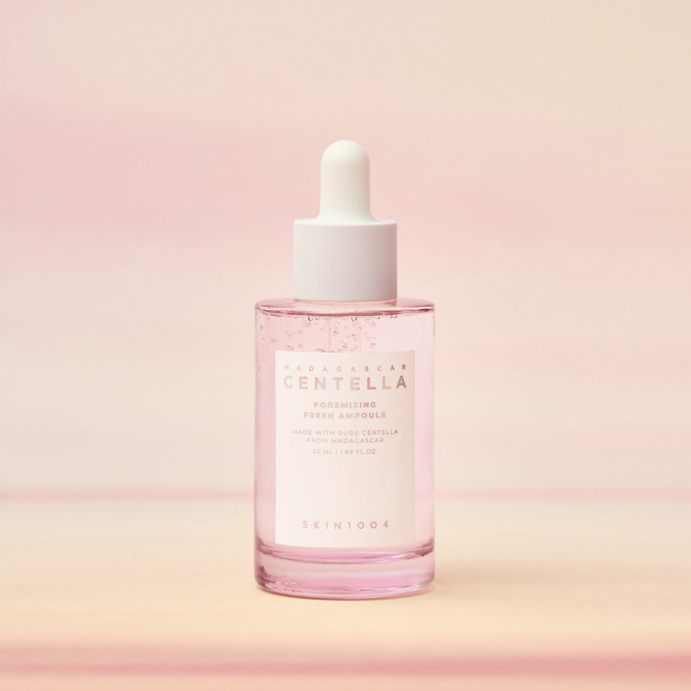 Pink skincare serum bottle with white cap on a pink gradient background