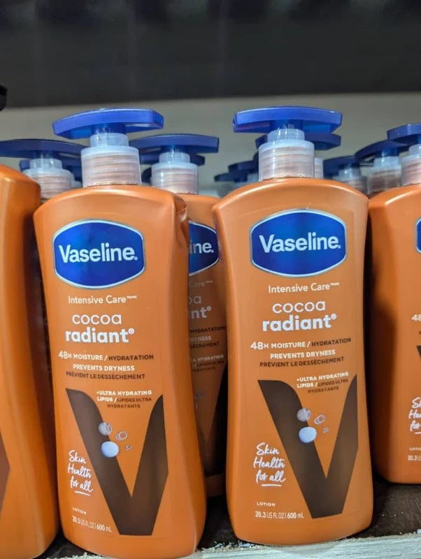 Multiple bottles of Vaseline Intensive Care cocoa radiant lotion on a shelf.