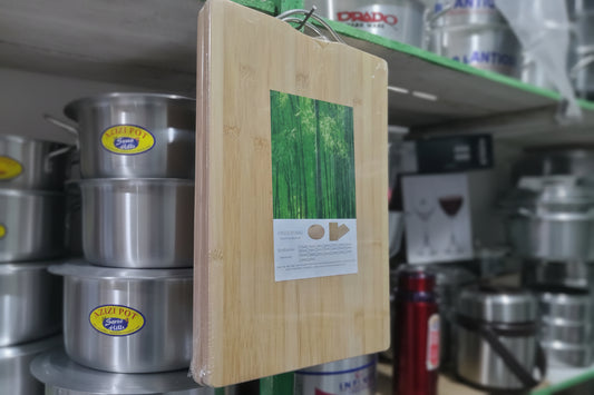Wooden cutting board with a green leaf design on a metal surface with labels.