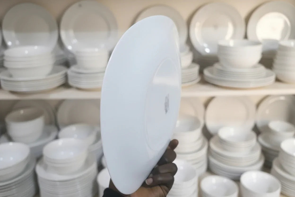 White circular object held by a hand in a workshop setting