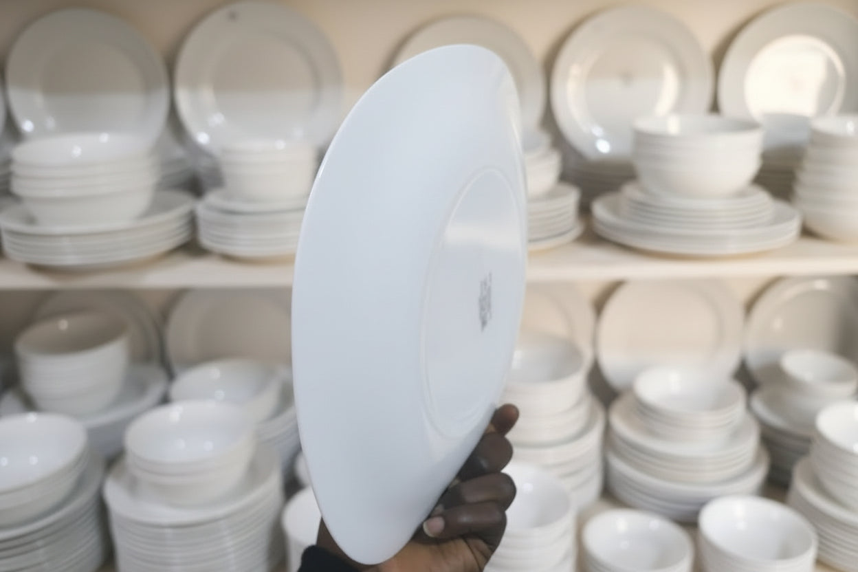 White circular object held by a hand in a workshop setting