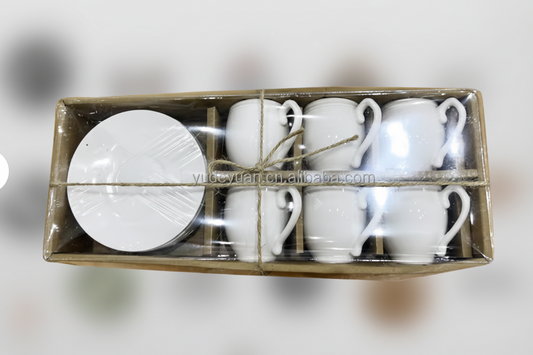 Set of white ceramic mugs and saucers in a cardboard box on a white background