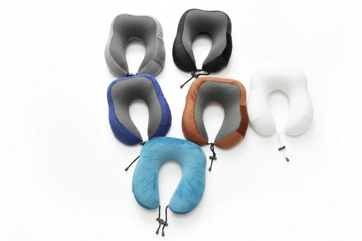 Set of travel neck pillows in various colors on a concrete floor.