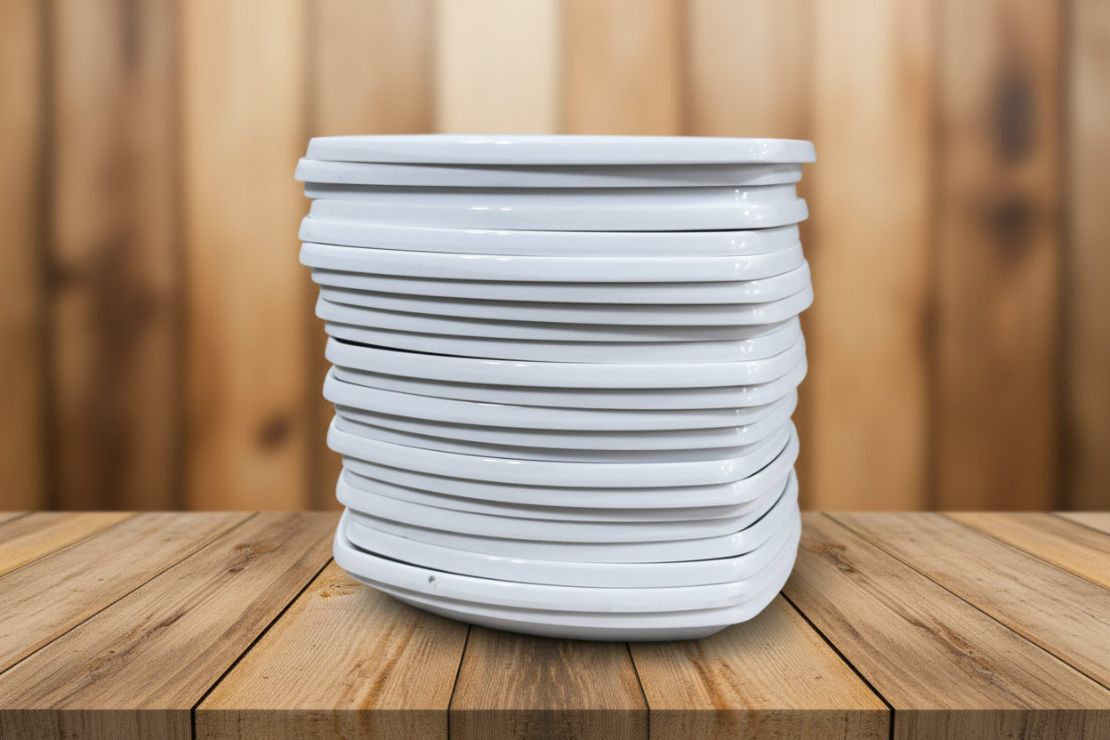 Stack of white ceramic plates with various kitchen items in the background