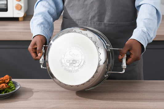 Person holding a metallic pot lid with a kitchen setting in the background