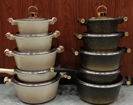 Set of stacked cookware pots and pans on a wooden background