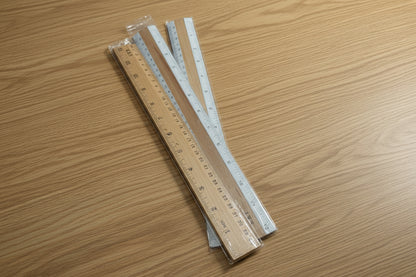  a set of wooden rulers with metal edges against a clutteR