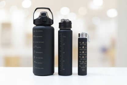 Black  bottles with measurement markings on a wooden surface.
