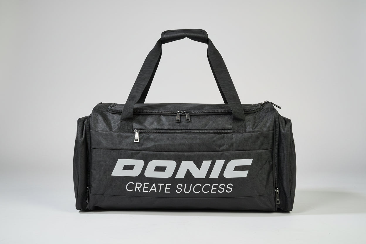 Black duffel bag with 'DONIC CREATE SUCCESS' text on a suitcase.