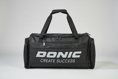 Black duffel bag with 'DONIC CREATE SUCCESS' text on a suitcase.