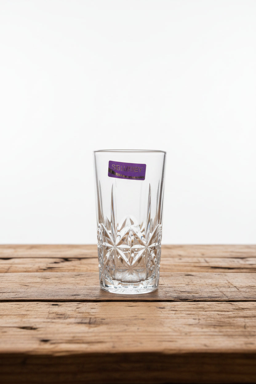 Clear glass with purple label held in front of a market scene
