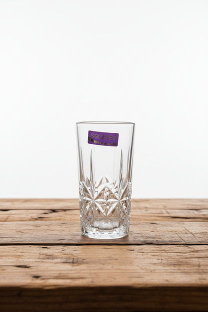 Clear glass with purple label held in front of a market scene