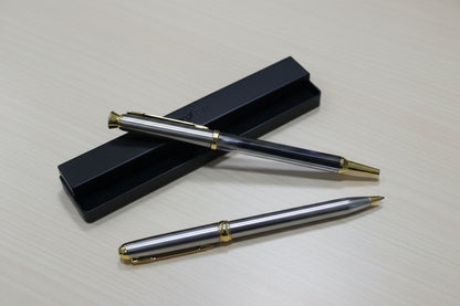 two golden pens placed on a table 