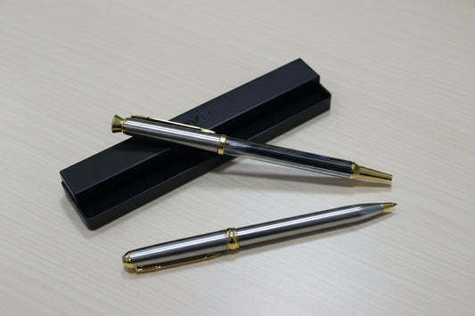 two golden pens placed on a table 