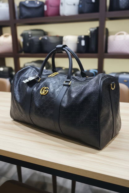 Black Gucci bag with a gold logo handle held by a person in a store setting.