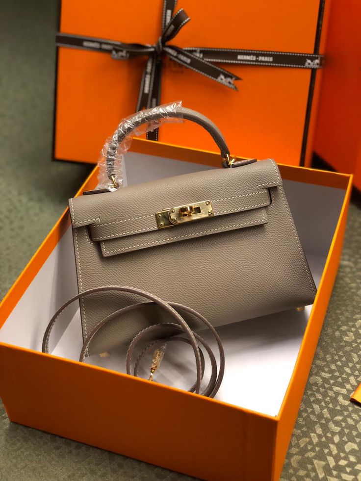 Gray handbag with gold hardware in an orange box