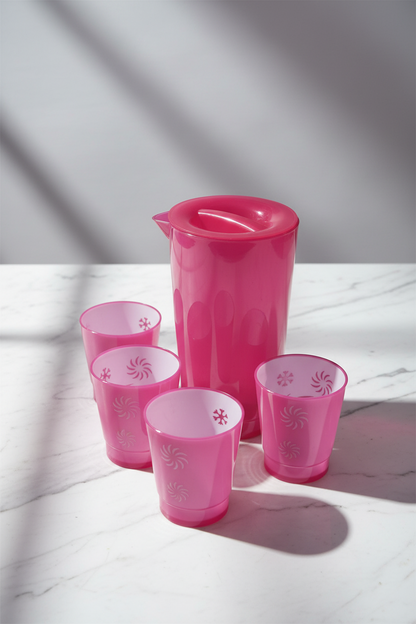 Set of pink cups with floral patterns on a table with clear glassware.