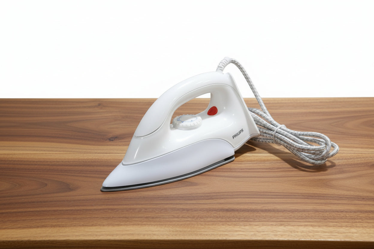 White iron held by a hand with spools of thread and other items in the background