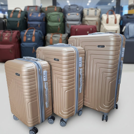 Three beige suitcases with a textured pattern on wheels in a store setting.