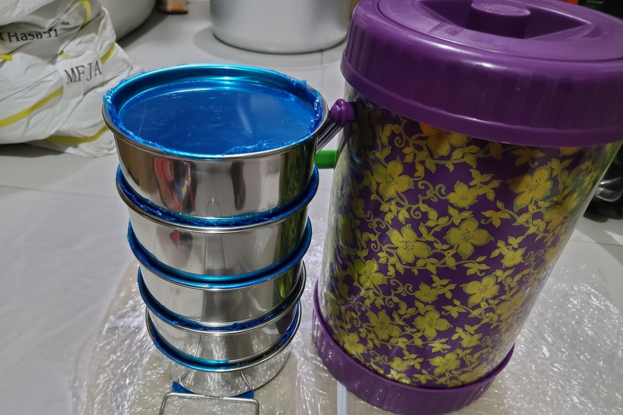 Metallic spiralizer with green bowl on a white background