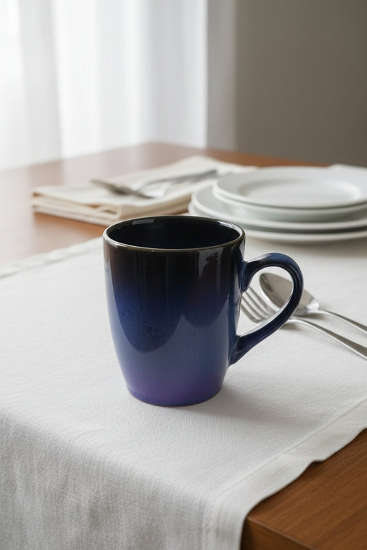 Blue mug on a white surface with a cluttered background