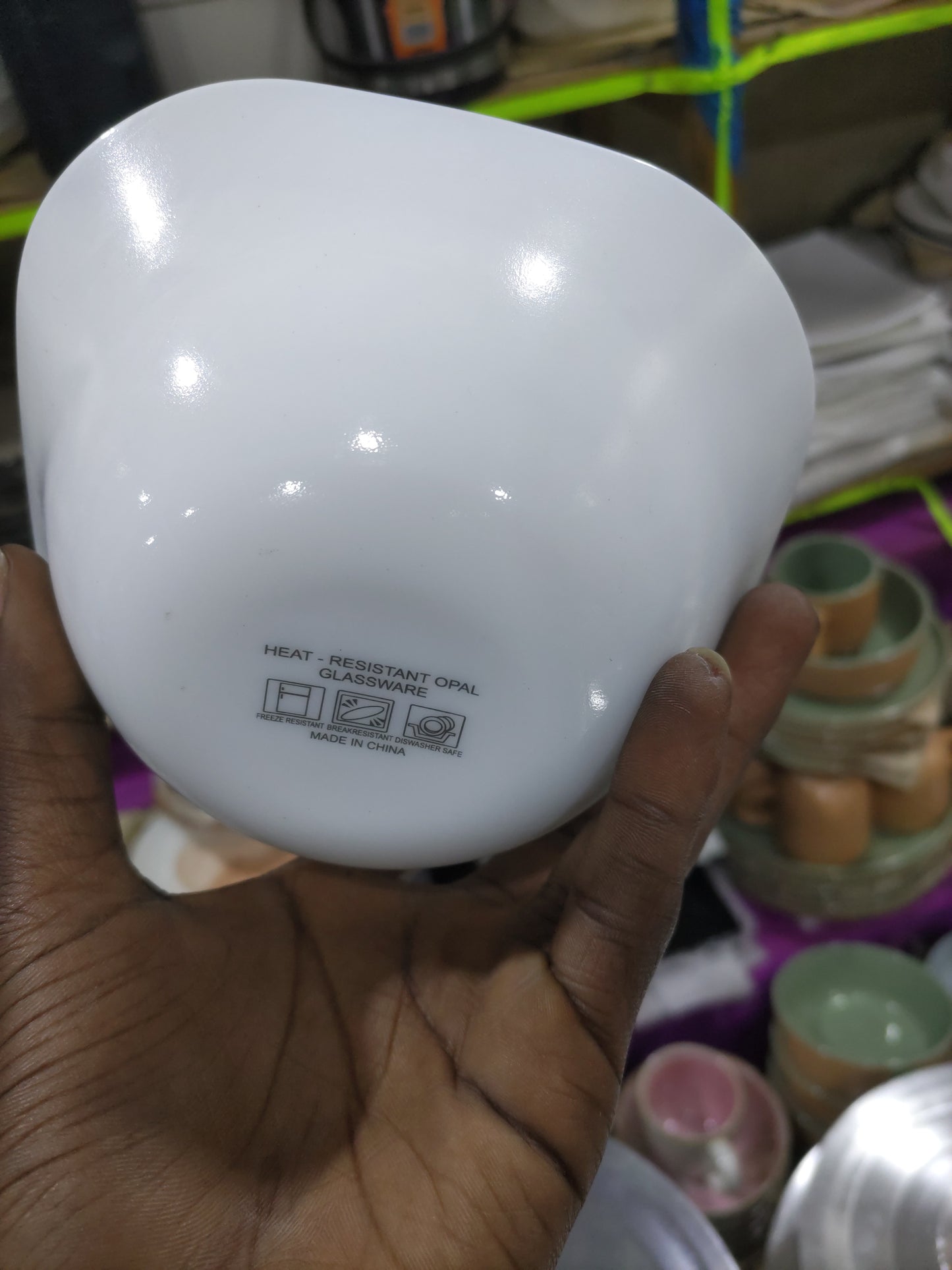 Hand holding a white light bulb with a blurred background