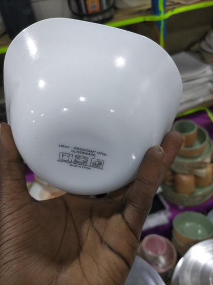Hand holding a white light bulb with a blurred background