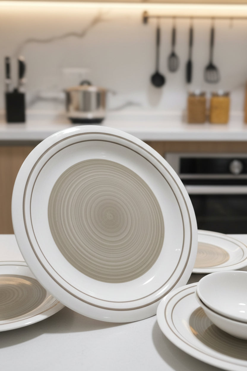 Round ceramic dish with concentric circles on a cluttered floor.