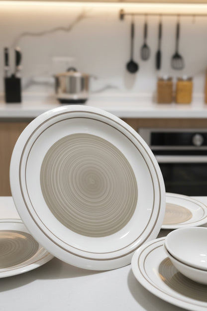 Round ceramic dish with concentric circles on a cluttered floor.