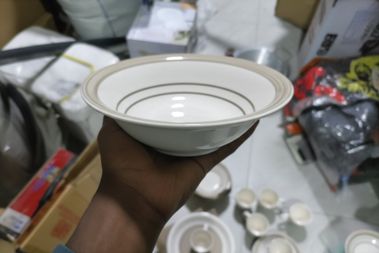 White ceramic lid held by a hand with a blurred background