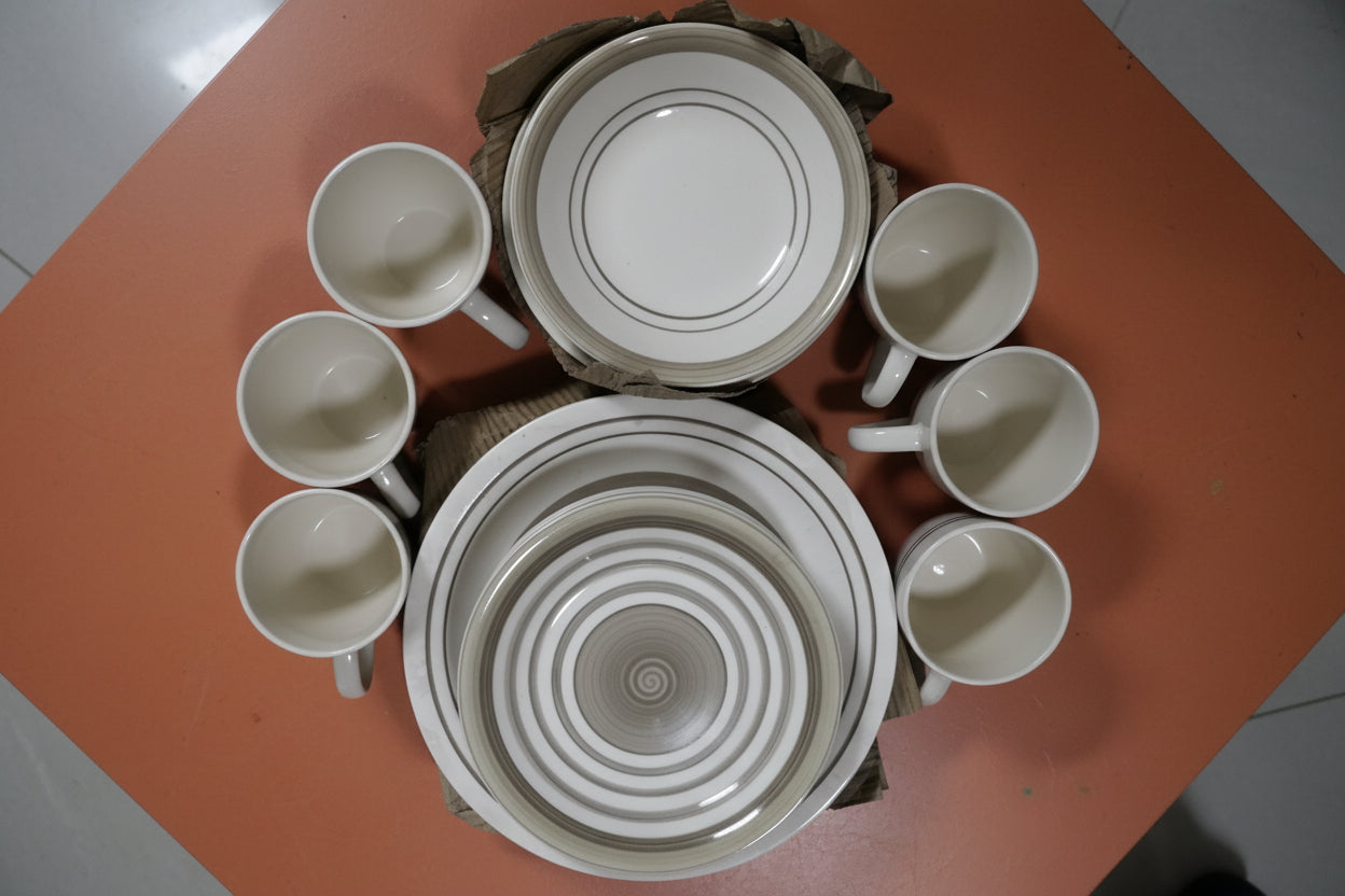 Stack of ceramic cups and lids in a metal bowl