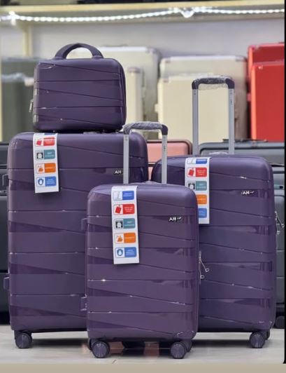 Set of purple suitcases with visible brand labels on a store shelf.