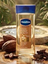 Vaseline cocoa butter body oil bottle on a wooden surface with cocoa beans and a blurred background