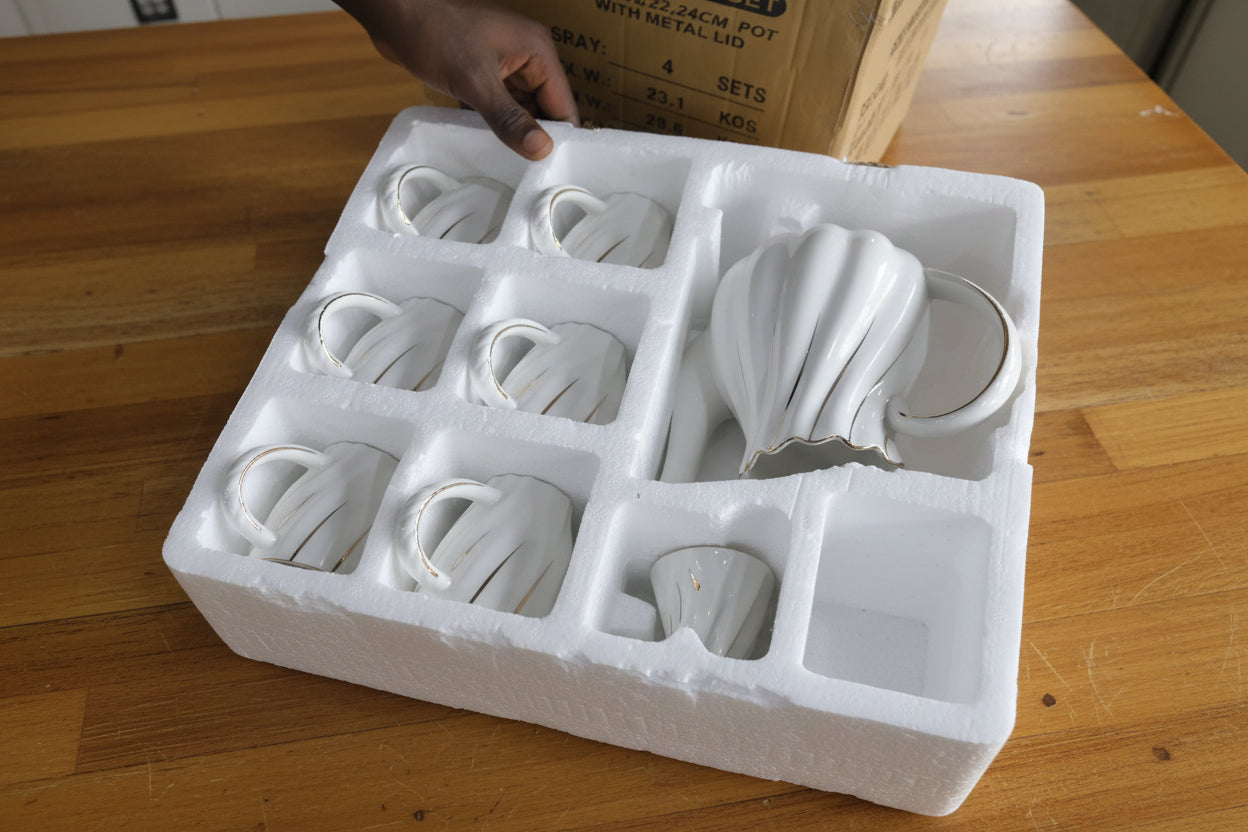Packaged light bulbs in styrofoam with a hand reaching towards them.