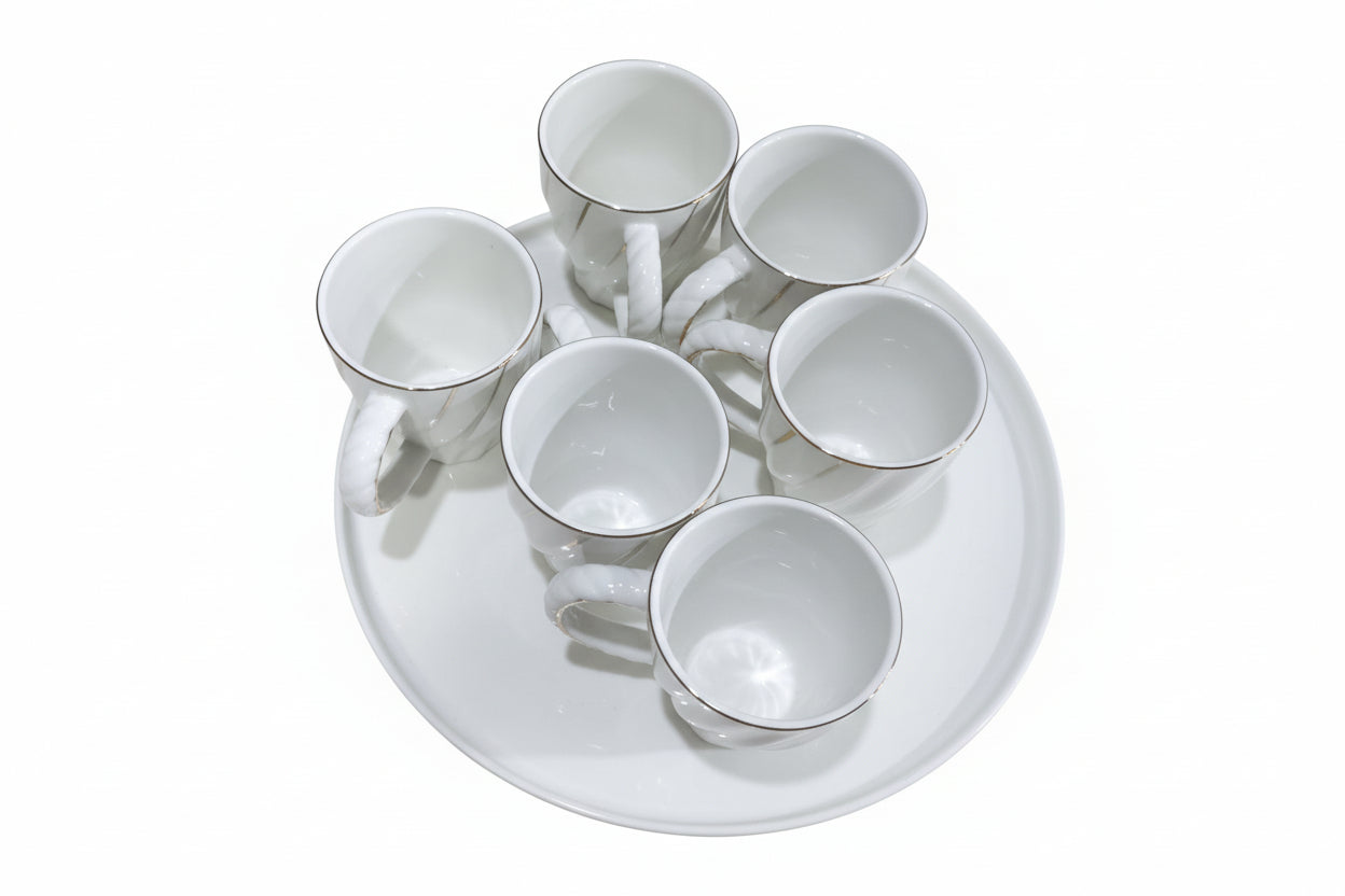 Set of white ceramic cups on a matching platter on a wooden surface