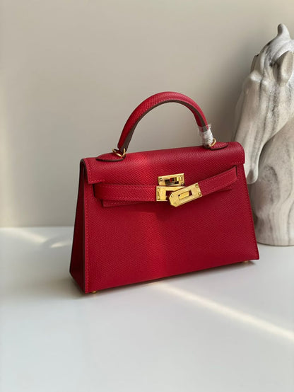 Red handbag with gold hardware on a light surface with a neutral background