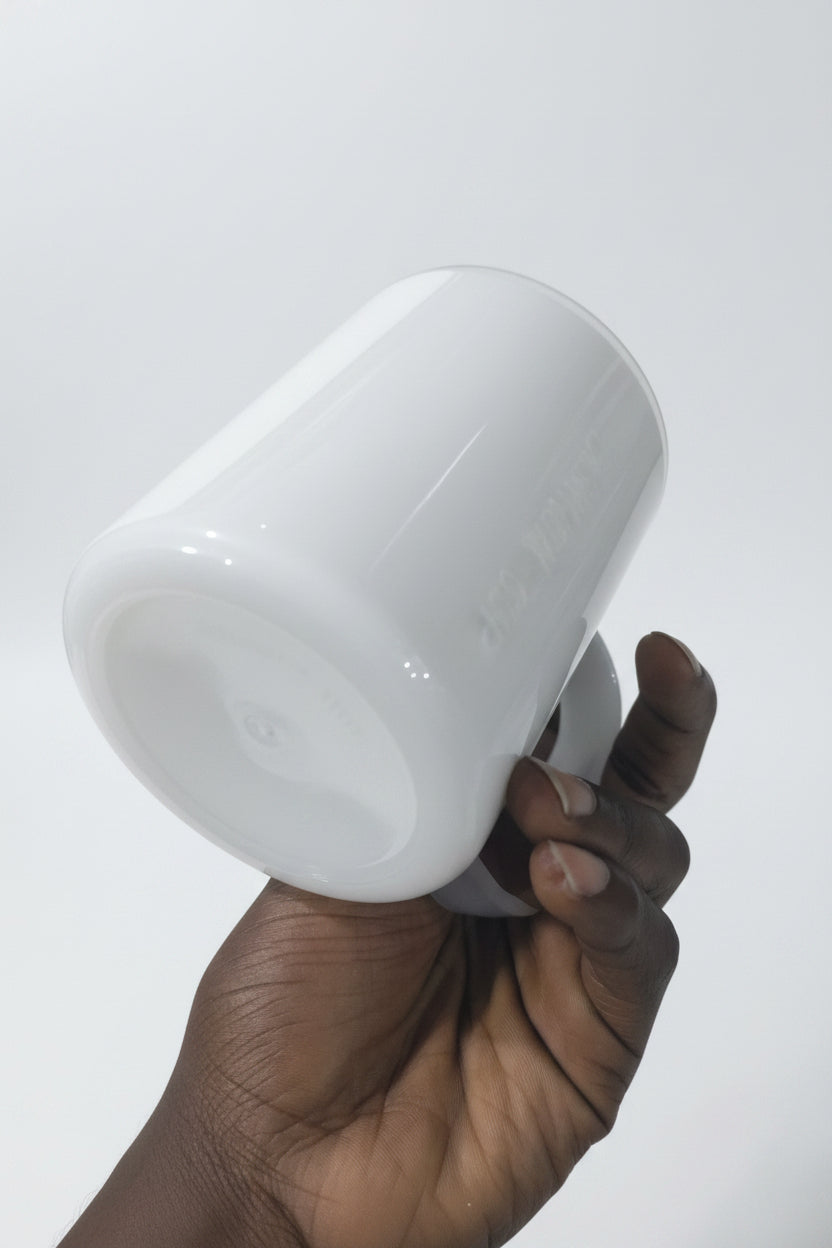 Hand holding a white light bulb in a store setting with various items in the background