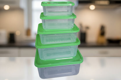 Stack of clear plastic food containers with green lids on a white background