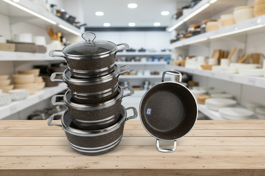 Set of black cookware with silver handles on a white background