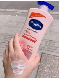Vaseline Daily Brightening lotion bottle with a hand applying the product.