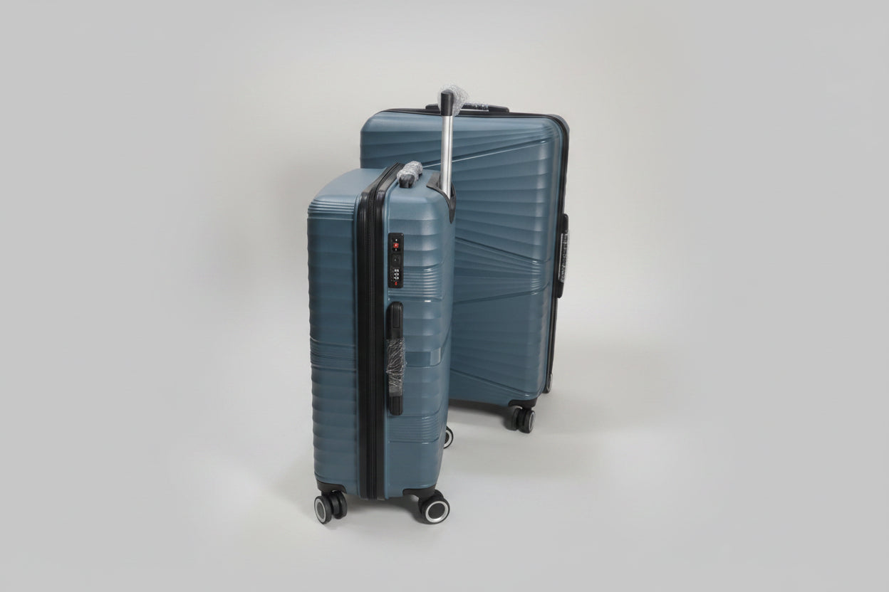 Two blue suitcases on wheels in a warehouse setting