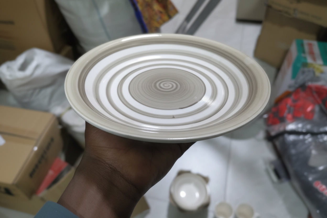 Round ceramic product with concentric circles on a cluttered surface