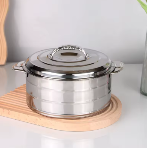 Stainless steel pot with lid on a wooden trivet