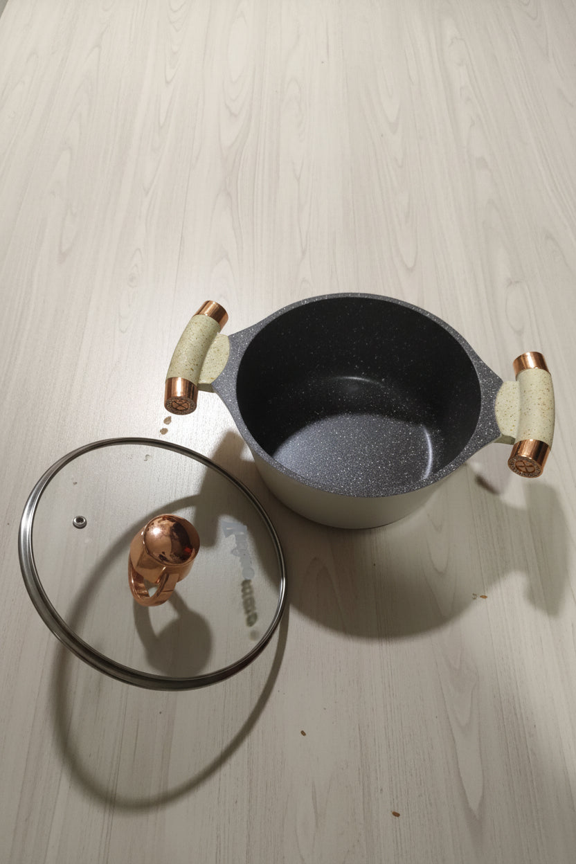 Gray frying pan with lid on a tiled floor