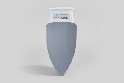 Gray Philips light bulb in a hand with a cluttered background