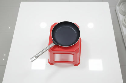 Frying pan on a red stool with a blurred background