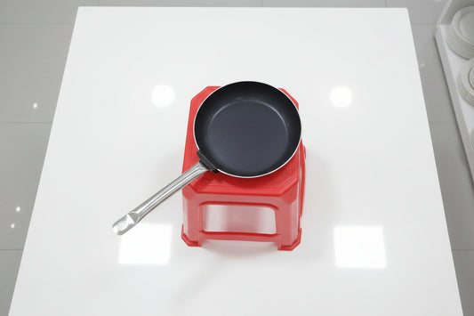 Frying pan on a red stool with a blurred background