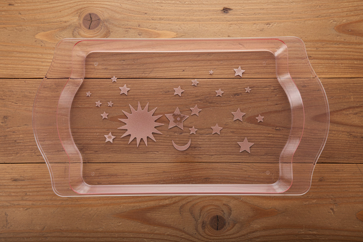 Plastic mold with star designs held by a person in a cluttered workshop.