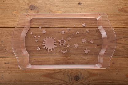 Plastic mold with star designs held by a person in a cluttered workshop.